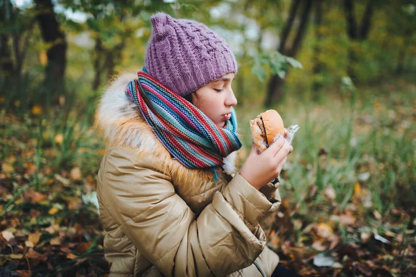 Portrait Hungry Teen Girl Sitting Ground Eating Burger Picnic Autumn Stock Image