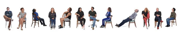 Büyük Bir Grup Insan Sandalyede Oturup Beyaz Arka Plana Bakıyor — Stok fotoğraf