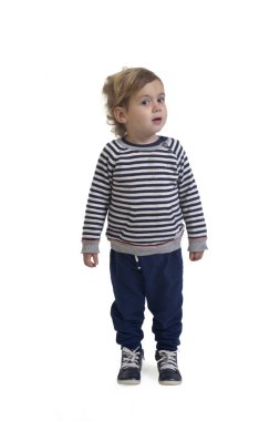 Beyaz arka planda duran ve kameraya bakan bir erkek bebeğin ön görüntüsü