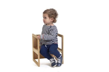 Beyaz arka planda sandalyede oturan bir çocuğun yan görüntüsü