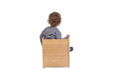 Beyaz arka planda, sandalyede oturan bir erkek bebeğin arka planı.