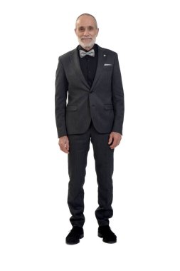 Takım elbiseli ve papyonlu bir adamın beyaz arka plandaki kameraya baktığı ön manzara.