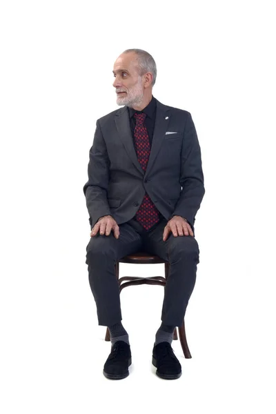 Άνθρωπος Κάθεται Στην Καρέκλα Κοιτάζοντας Μακριά Λευκό Φόντο — Φωτογραφία Αρχείου