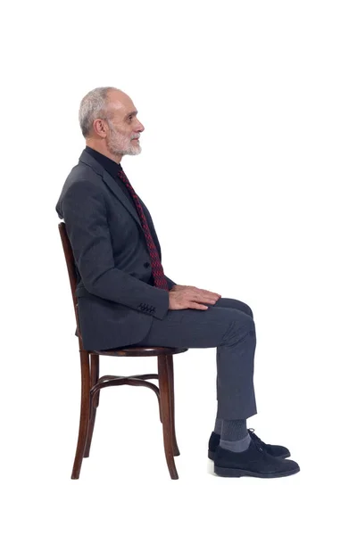 坐在椅子上 身穿西服 打着领带 白色背景的男人的侧视图 — 图库照片