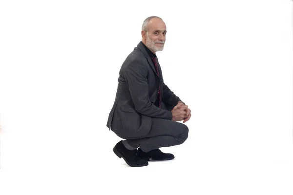 Side View Man Suit Squatting Looking Camera White Background — Stock Photo, Image