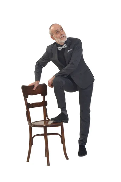 Άνδρας Παπιγιόν Και Κοστούμι Παίζει Μια Καρέκλα Και Κοιτάζει Πάνω — Φωτογραφία Αρχείου