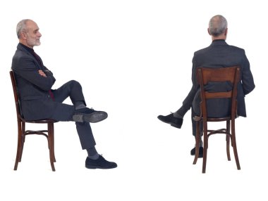 Beyaz arka planda kravatlı, sandalyede oturan bir adamın yan ve arkası.