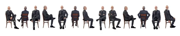 スーツを着た同じ男の大集団の列と白い背景の椅子に座るタイ弓 — ストック写真