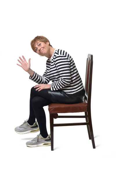 Seitenansicht Einer Frau Die Mit Erhobener Hand Auf Einem Stuhl — Stockfoto