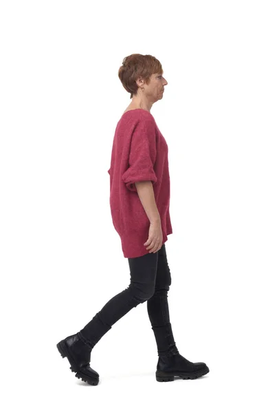 サイドビューの女性の完全な長さの肖像画白い背景にタイトなジーンパンツで歩く — ストック写真