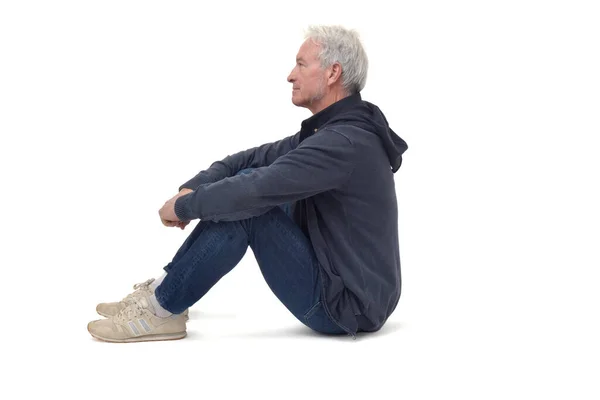 Homem Sentado Chão Com Pernas Dobradas Olhando Para Longe Fundo — Fotografia de Stock