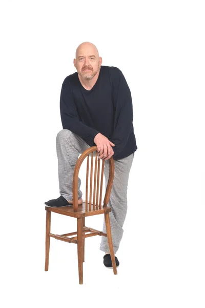一个穿着睡衣的男人站在长椅上 看着白色背景的相机的前视图 — 图库照片