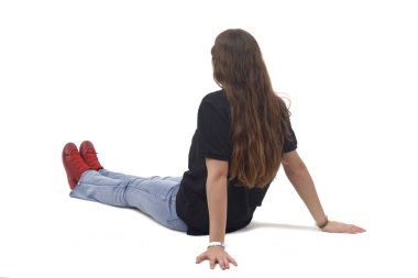 Beyaz arka planda esnemiş bacaklarla yerde oturan genç bir kızın arka ve yan görüntüsü.