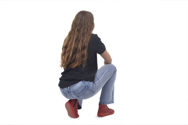 back and side  view of a young girl long-haired sitting squatting on white background