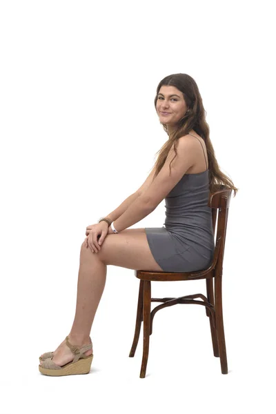 Vista Lateral Menina Sentada Cadeira Feliz Olhando Para Câmera Fundo — Fotografia de Stock