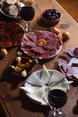 tapas and red wine on wooden table