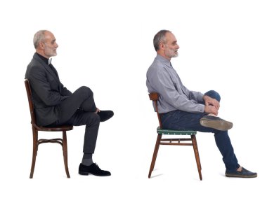 Aynı adamın beyaz arka planda oturan, takım elbise giyen ve günlük giysiler giyen görüntüsü.