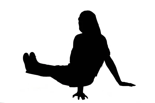 白い背景に伸ばされた足で床に座っている若い女の子のシルエットの側面とバックビュー — ストック写真