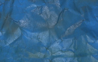 Buruşmuş krantf kağıdı sprey boyayla maviye boyanmış.