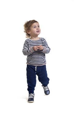 Beyaz arka planda yürüyen ve yukarı bakan bir erkek bebeğin ön görüntüsü