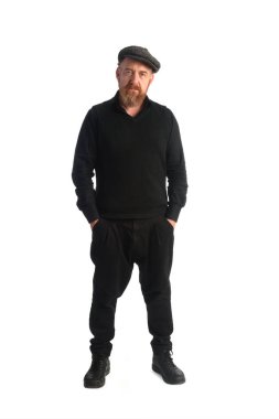 Bembeyaz arka planda duran ve kameraya bakan okuyucu adam.