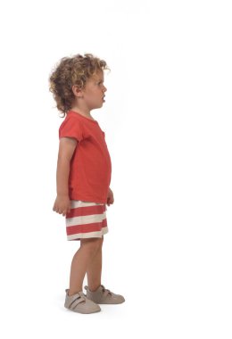 Yazın beyaz arka plan giymiş bir çocuğun yan görüntüsü (3 yaşında))