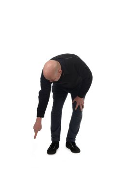 Çömelmiş bir adamın beyaz arka planda yere parmağını göstermesi.