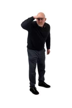 Elini alnına koyup beyaz arka plandaki mesafeye bakan bir adamın ön görüntüsü.