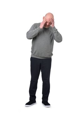 Beyaz arka planda izole edilmiş baş ağrısı çeken bir adamın uzun bir portresinin ön görüntüsü