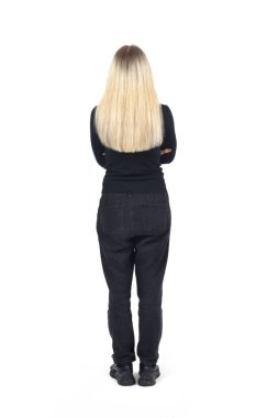 Beyaz arka planda kolları çapraz duran sarışın bir kadının dikiz görüntüsü.