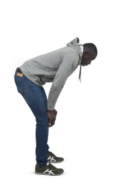 Beyaz arka plana bakan çömelmiş bir adamın yan görünüm portresi.