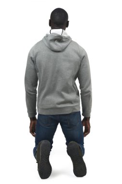 Beyaz arka planda diz çökmüş bir adamın