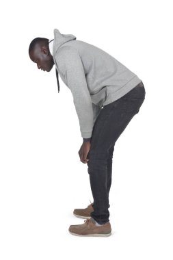 Beyaz arka planda çömelmiş ve yere bakan bir adamın yan görüntüsü