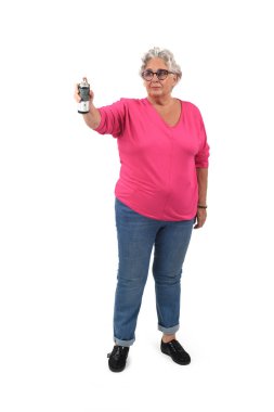 Beyaz arka planda sprey boyayla resim yapan son sınıf bir kadının ön görüntüsü