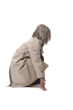 Beyaz arka planda çömelmiş bir kadının yan görüntüsü