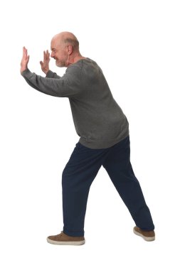 side view of man holding or squeezing a wall or something imaginary on white background