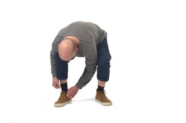 man tying shoelaces on white background