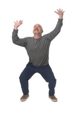 front view a man standing holding or pushing up something imaginary and his armpits sweat from the effort