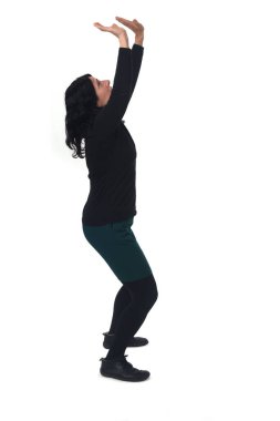 side view of a standingwoman holding or pushing something imaginary upwards.