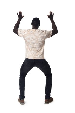 back view of a standing man holding or pushing something imaginary upwards.