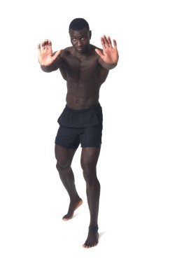 Front view of a man wearing shorts pushing an imaginary wall.