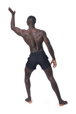 Rear view of a man wearing shorts pushing something imaginary upwards with one hand.