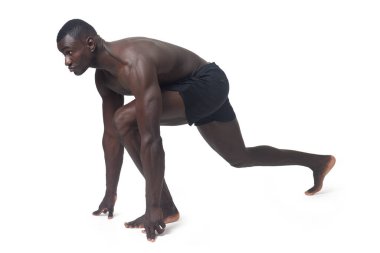side view of a man wearing shorts in starting position for a race.