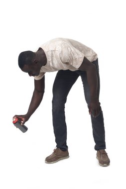 side view of a crouching man painting with a spray