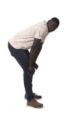 side view of a man standing leaning forward looking at camera on white background