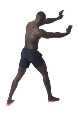 back side view of a man wearing shorts pushing an imaginary wall.