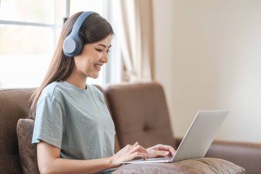 Bilgisayarlı akıllı Asyalı kadın evde bilgisayar öğreniyor. Yüksek kalite fotoğraf