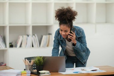Güzel bir ofiste çalışan zeki Afrikalı kadınlar, dizüstü bilgisayarla çalışan, telefonu kullanan, cep telefonuyla konuşan. - Evet. Yüksek kalite fotoğraf