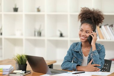 Güzel bir ofiste çalışan zeki Afrikalı kadınlar, dizüstü bilgisayarla çalışan, telefonu kullanan, cep telefonuyla konuşan. - Evet. Yüksek kalite fotoğraf