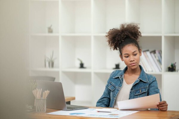 Smart African women working in beautiful office, working on Laptop, use the phone, talking on the cellphone. . High quality photo